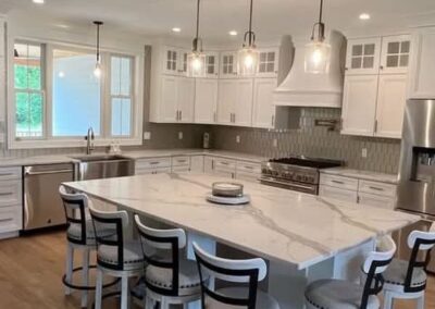 Gray and gold veining on white quartz complimented by glass tile backsplash.